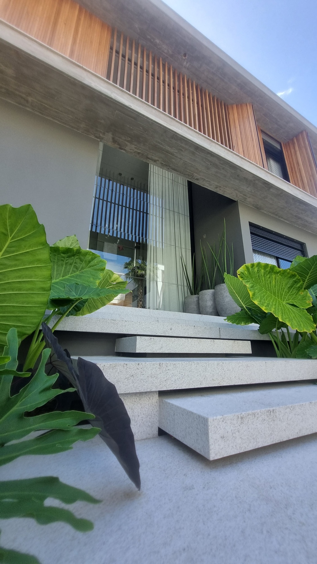 Grande abertura residencial com esquadria de alumínio e integração entre interior e exterior